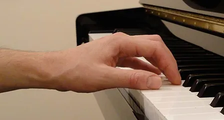 A hand over a piano, getting set to play